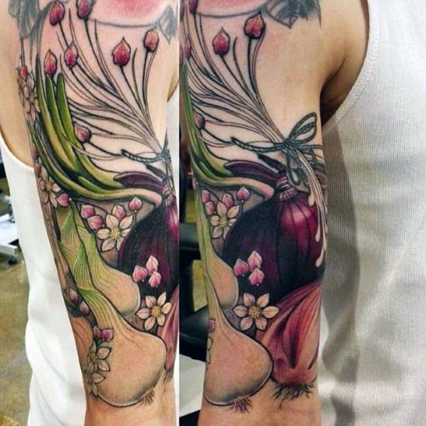 Vibrant full-sleeve tattoo featuring onions, garlic, flowers, and herbs, blending realism with botanical elements in rich colors and fine details.