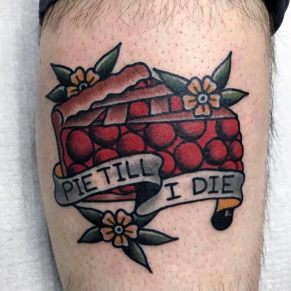 Traditional cherry pie tattoo with a dripping filling, floral accents, and a banner reading “Pie Till I Die,” blending classic Americana with a fun, bold statement