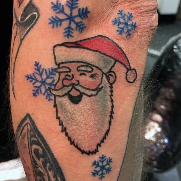 Minimalist Santa Claus tattoo with a playful expression, simple bold outlines, festive red hat, and blue snowflakes for a cheerful holiday vibe.