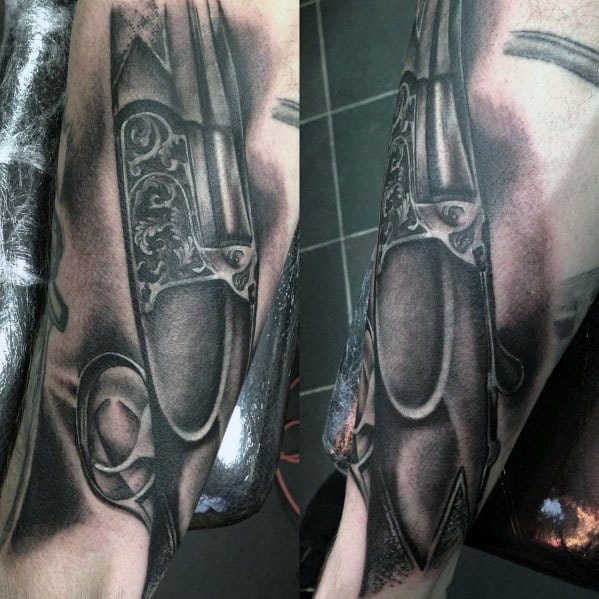 Realistic black and grey tattoo of an engraved double-barrel shotgun, featuring intricate detailing and fine shading for a bold and elegant design.