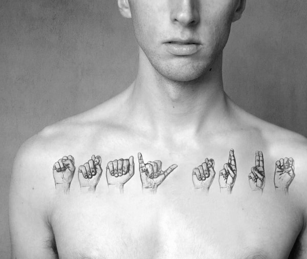realistic black and grey tattoo of hands spelling a word in American Sign Language, placed across the upper chest with detailed shading