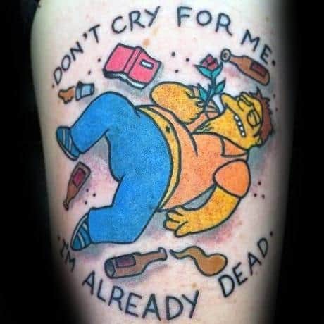 Colorful tattoo of Barney Gumble from The Simpsons lying on the ground with bottles around him, holding a rose, with 'Don't cry for me, I'm already dead' text.