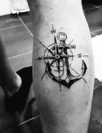 Anchor and compass tattoo with fine-line detailing, symbolizing stability, direction, and a strong connection to the sea.