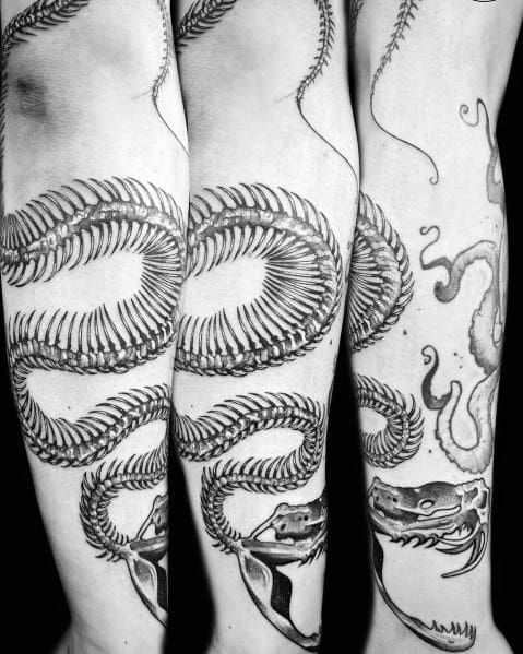 Snake skeleton tattoo on the forearm, featuring intricate rib details and a coiled design with bold shading for a striking and dynamic look.