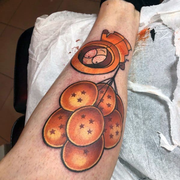 South Park tattoo of Kenny floating away with Dragon Balls as balloons, featuring bold colors, shading, and a creative crossover design.