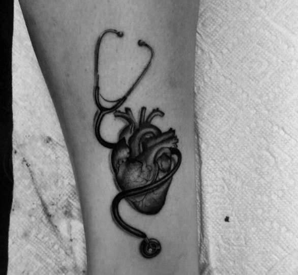 Realistic anatomical heart tattoo with a stethoscope wrapped around it, symbolizing a deep passion for cardiology and dedication to the medical field.