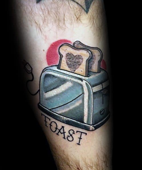 Retro-style toaster tattoo with two slices of toast, one featuring a heart-shaped design, and bold lettering spelling "TOAST" for a nostalgic touch.