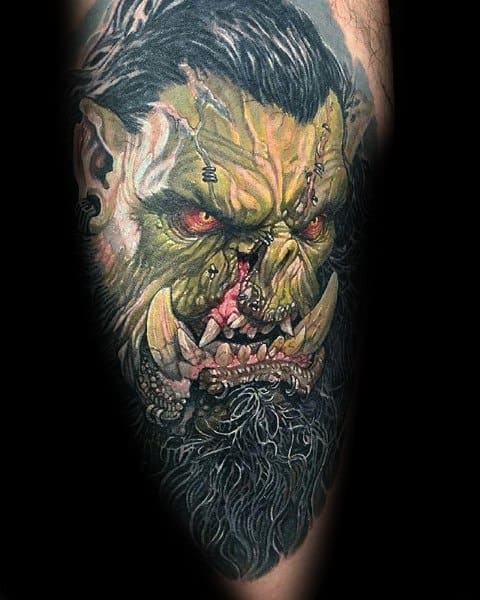 Hyper-realistic tattoo of a fierce orc from World of Warcraft, featuring glowing red eyes, sharp tusks, battle scars, and intricate shading, inked on the arm.