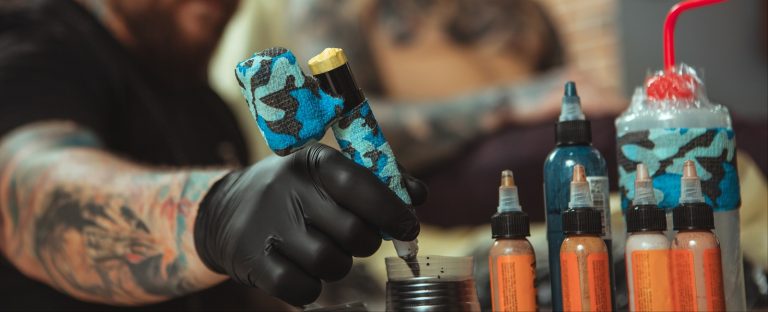 tattooist refilling the pen, making tattoo for a client