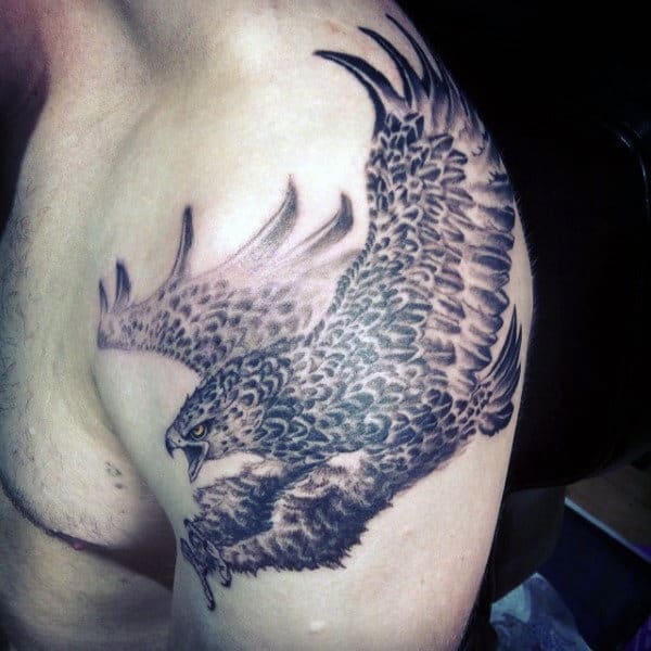 Tattoo of a detailed aggressive eagle in flight on a person's upper arm