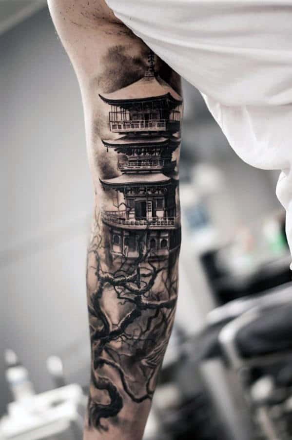Tattoo of a pagoda and tree branches on a person's arm