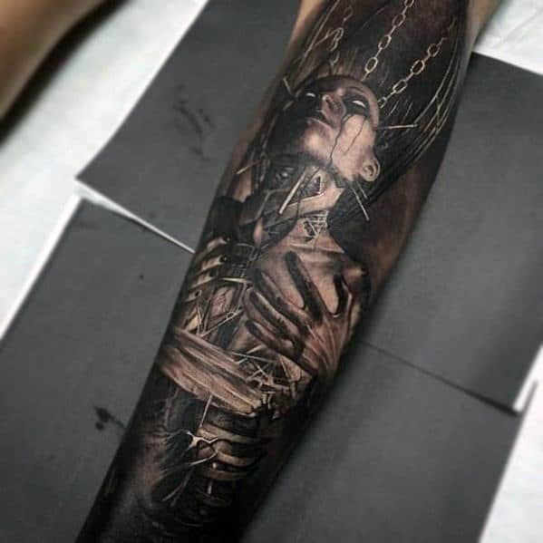 A realistic tattoo of a person with chains and dark shading on an arm