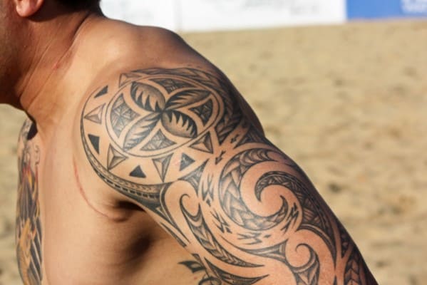 Man with intricate geometric tattoo on shoulder and upper arm