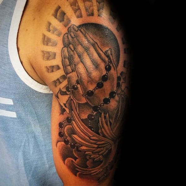 Tattoos Of A Rosary On Man With Sun Rays And Dove On Upper Arm