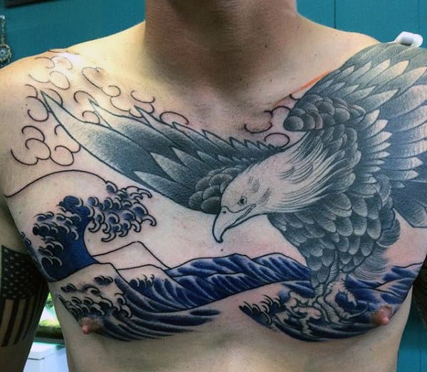 Chest tattoo of an eagle with outstretched wings soaring over waves and mountains