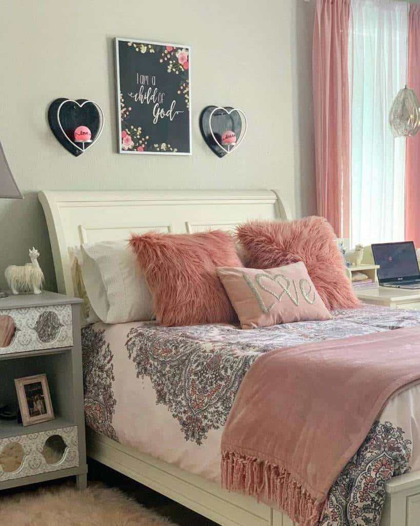 Teen bedroom with floral wall art, heart decor, pink pillows, and cozy bedding.
