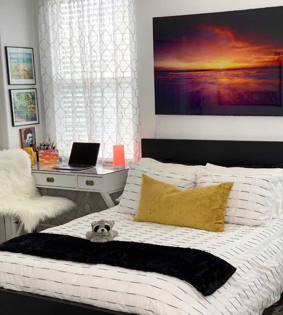 Bright bedroom with striped bedding white desk sunrise wall art and cozy decor accents.