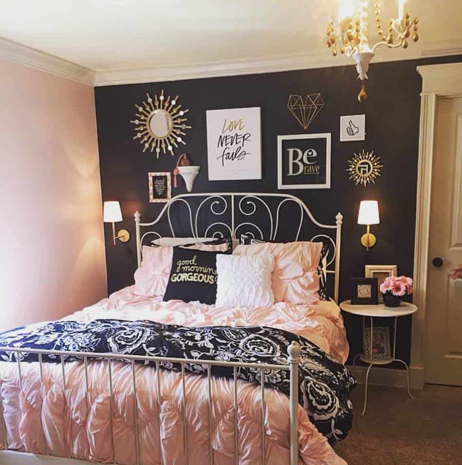 Girly bedroom with black accent wall gallery art gold chandelier and pink bedding.