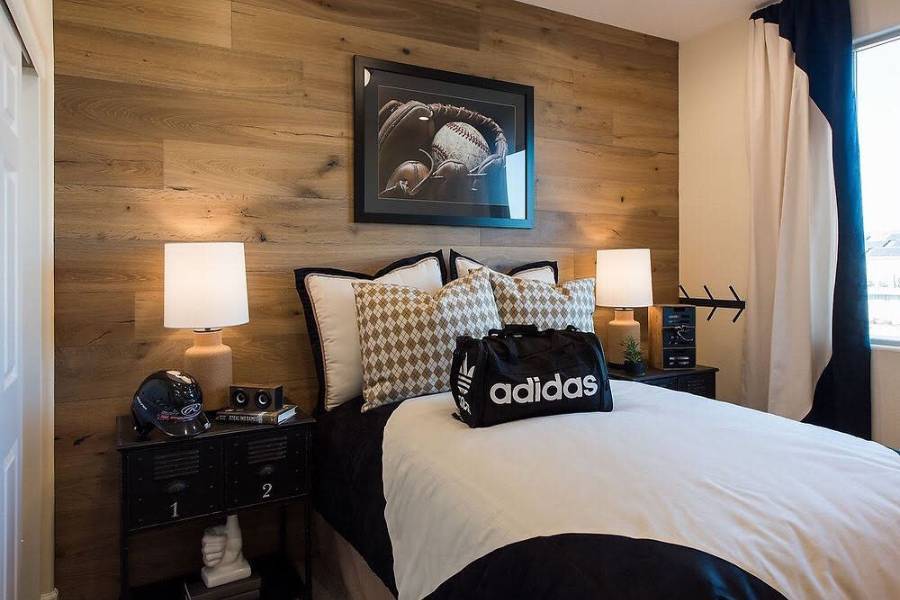 Baseball-themed bedroom with wood panel wall, sports decor, and Adidas bag on bed.