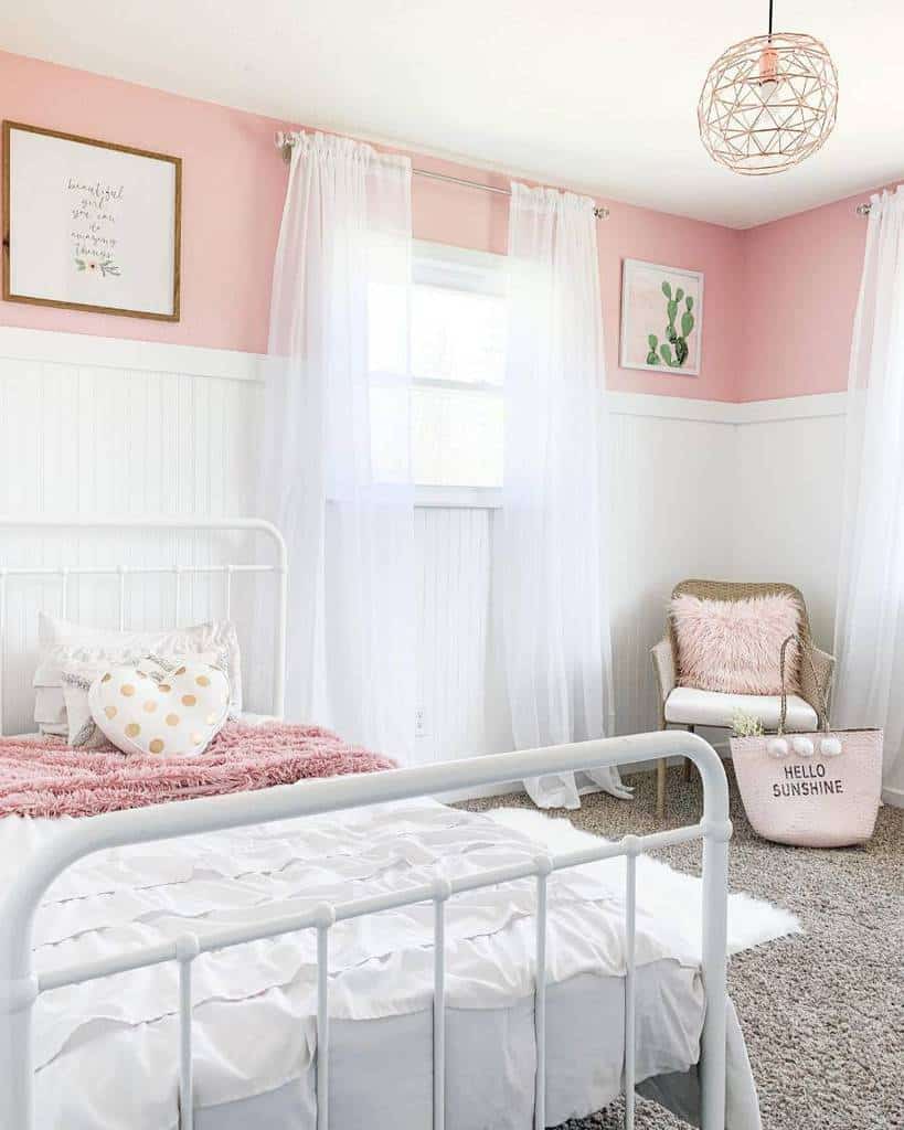 Girly bedroom with pink and white walls, orb ceiling light, and cozy decor.