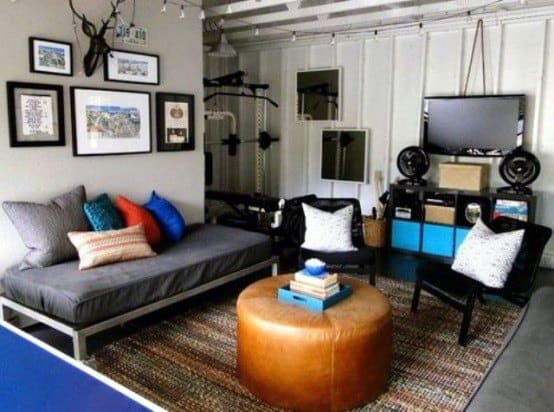Stylish living room with a daybed, colorful pillows, a leather ottoman, wall art, and a TV; gym equipment in the corner