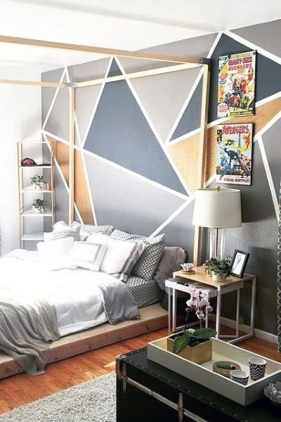 Modern bedroom with geometric wall design, a canopy bed, comic book art, and a small side table with a lamp