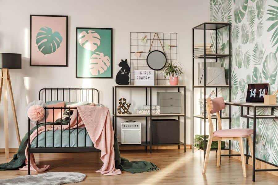 Contemporary girl’s bedroom with palm wallpaper, metal bed, and modern shelving units.