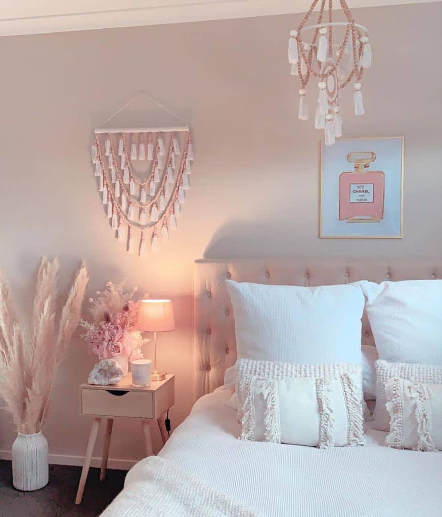 Cozy bedroom with decorative pillows, soft lighting, pampas grass, and wall art