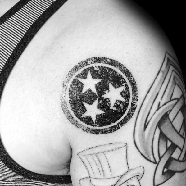 Distressed Tennessee three-star emblem tattoo on the shoulder, featuring a worn, vintage look that adds character and state pride.