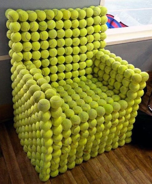 Unique armchair completely covered in yellow tennis balls, creating a playful and bold design statement.