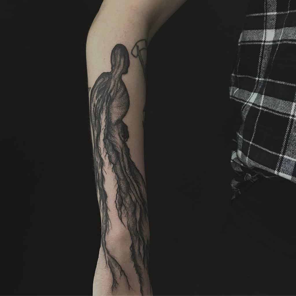 Dark tattoo of a Dementor in black ink, with eerie, flowing details capturing its haunting presence and fearsome aura