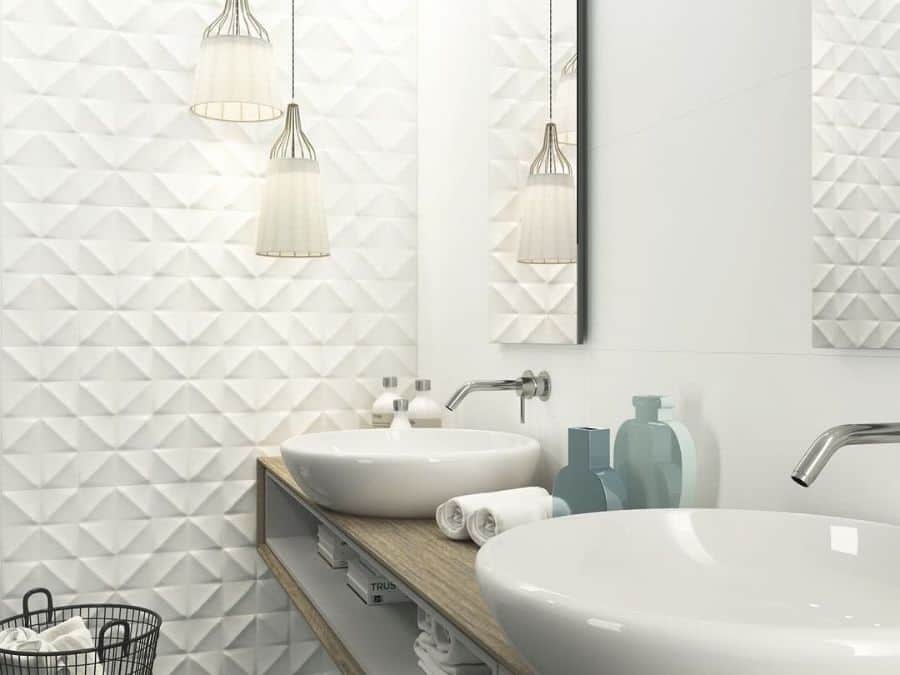 Modern bathroom with white textured wall, vessel sinks, and pendant lighting.