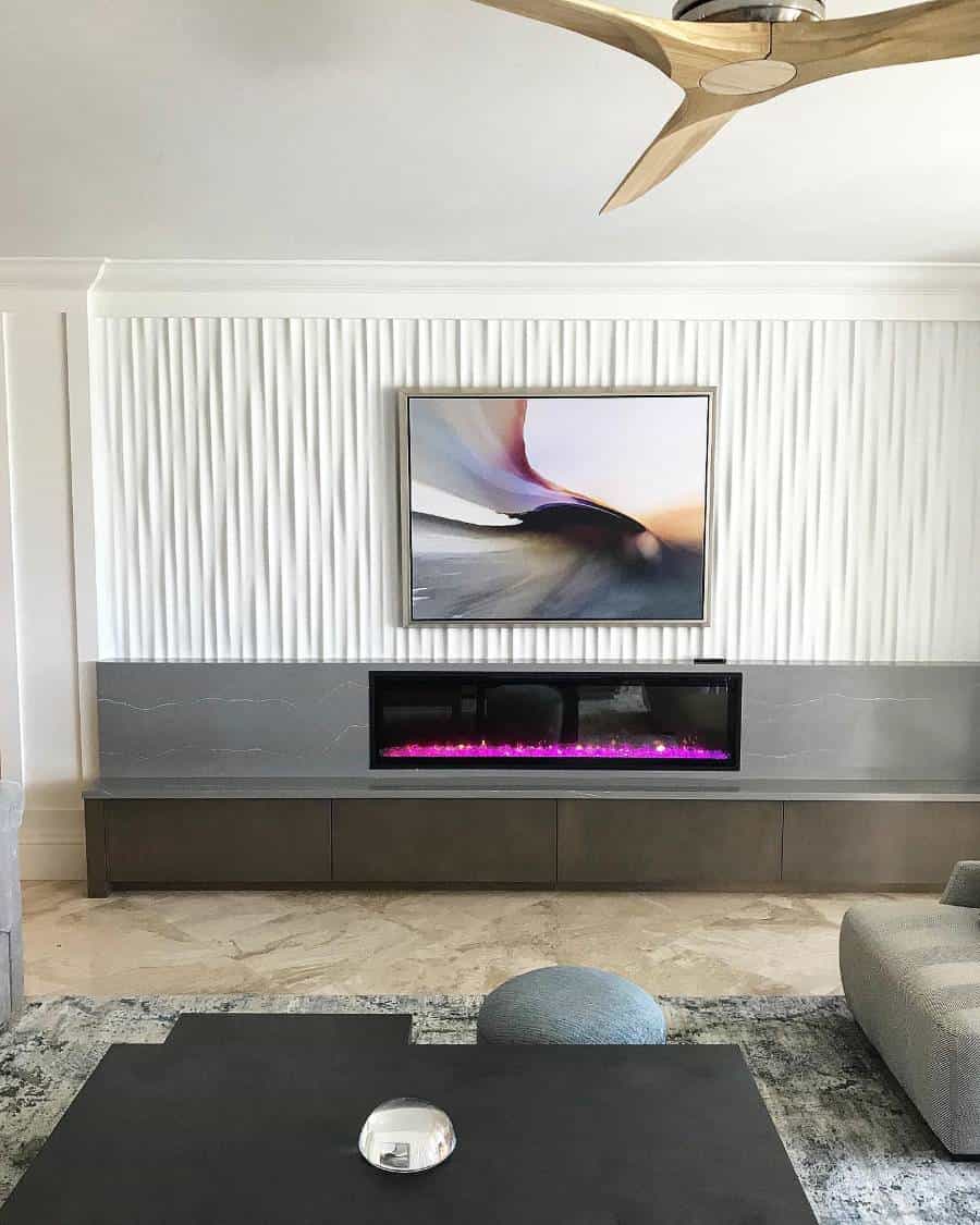 Modern living room featuring abstract art, an electric fireplace, an accent wall, and sleek furniture