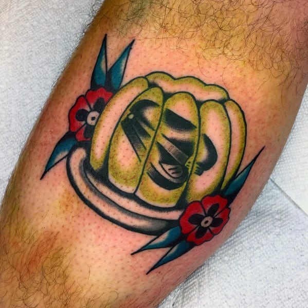 Color tattoo of a black stapler encased in green Jell-O, surrounded by flowers, referencing Jim’s classic prank on Dwight from *The Office*.