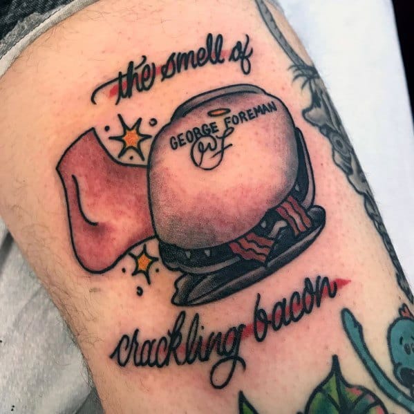 Color tattoo of a George Foreman grill with bacon and a foot, featuring the phrase "the smell of crackling bacon," referencing Michael Scott’s injury from *The Office*.