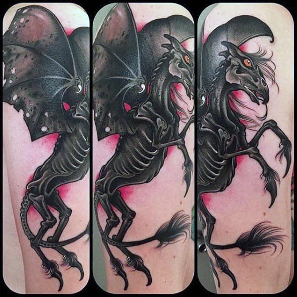 Vivid Thestral tattoo with black and red tones, glowing orange eyes, and detailed wings, set on a dynamic pose across the forearm.