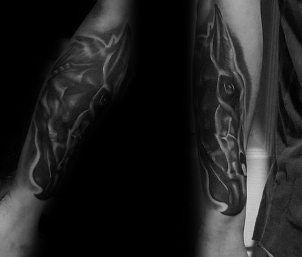 Realistic Thestral head tattoo with smooth black and grey shading, giving it a ghostly, ethereal look on the forearm.