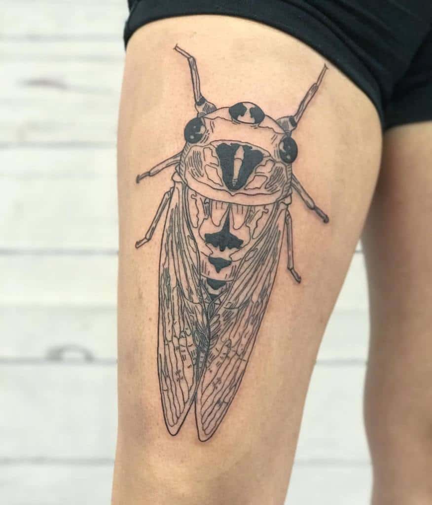 Large cicada tattoo on the thigh with bold outlines and detailed wing patterns, showcasing a minimalist design style