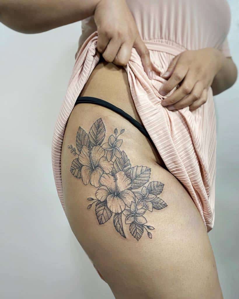 Elegant black and gray thigh tattoo featuring hibiscus and plumeria flowers with intricate leaf detailing