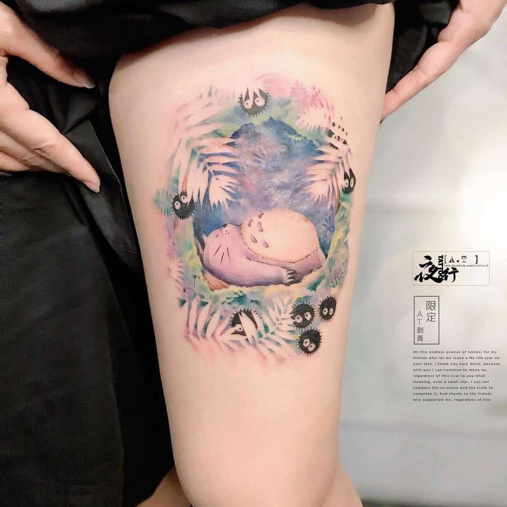 Dreamy thigh tattoo of Totoro surrounded by colorful foliage and soot sprites, creating a whimsical forest vibe