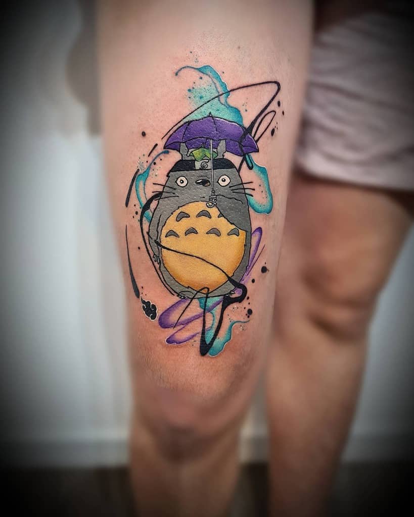 Bold Totoro thigh tattoo featuring a purple umbrella, dynamic lines, and watercolor splashes for a lively, artistic effect