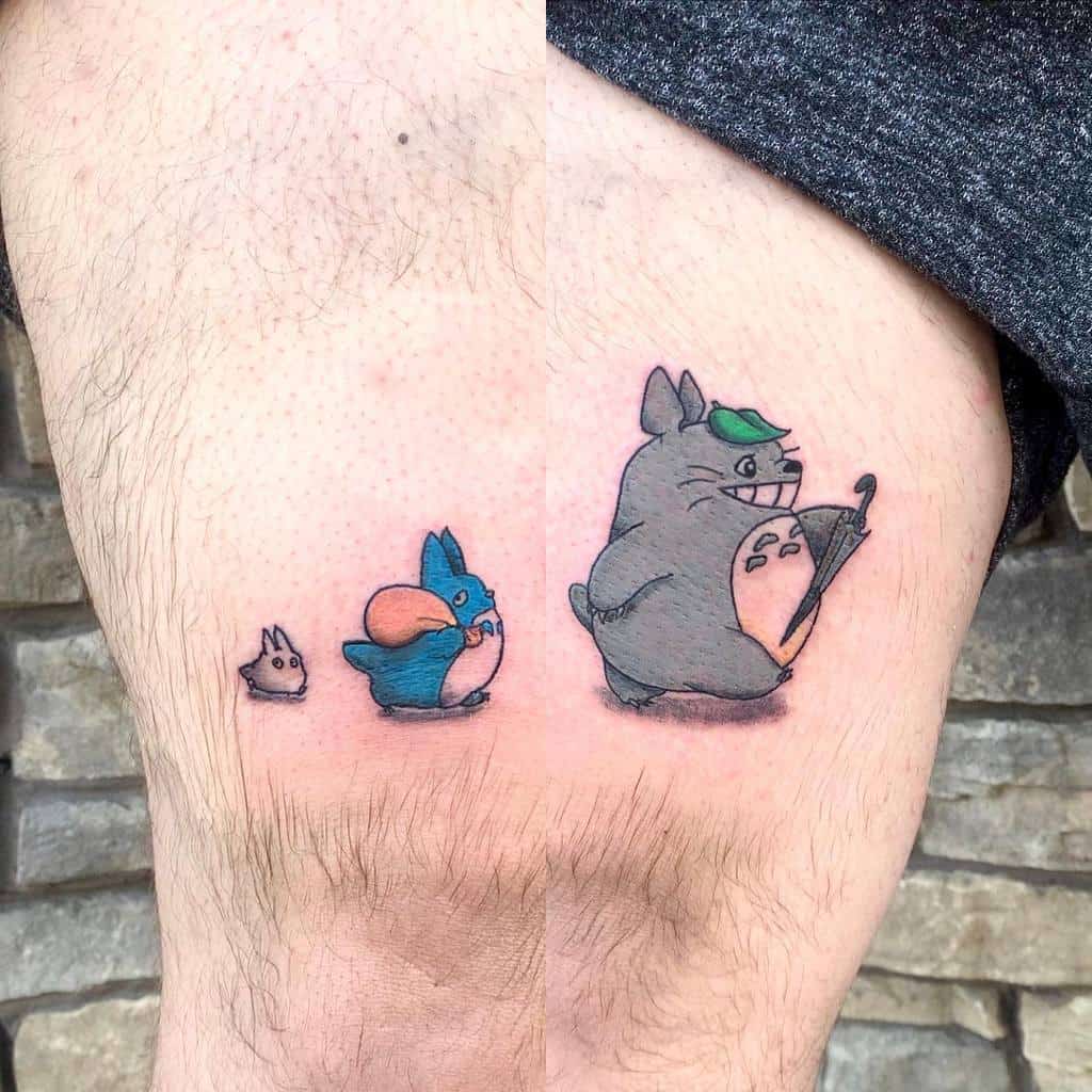 Cute Totoro tattoo with small creatures on a thigh