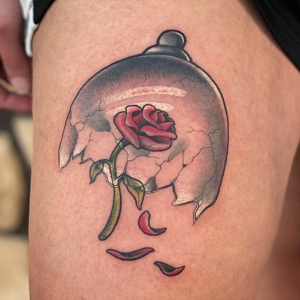 Tattoo of a red rose under a cracked dome with falling petals