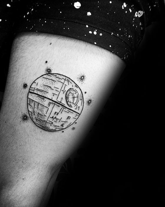 Inked Death Star tattoo adorns a thigh, in striking black and white