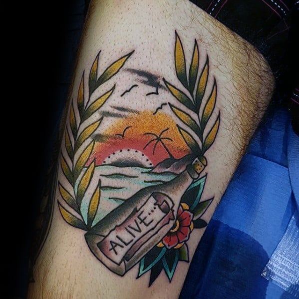Tattoo of a sunset beach scene with a message in a bottle labeled "ALIVE" and laurel leaves