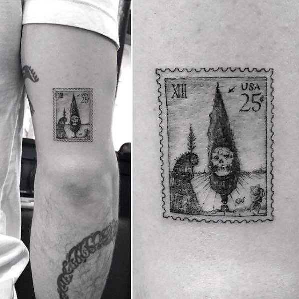 A black and white tattoo of a surreal postage stamp graces a person's arm, capturing timeless elegance and artistry