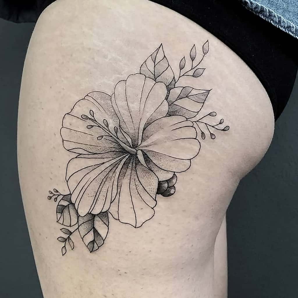 Black and gray hibiscus flower tattoo on upper thigh with detailed leaves