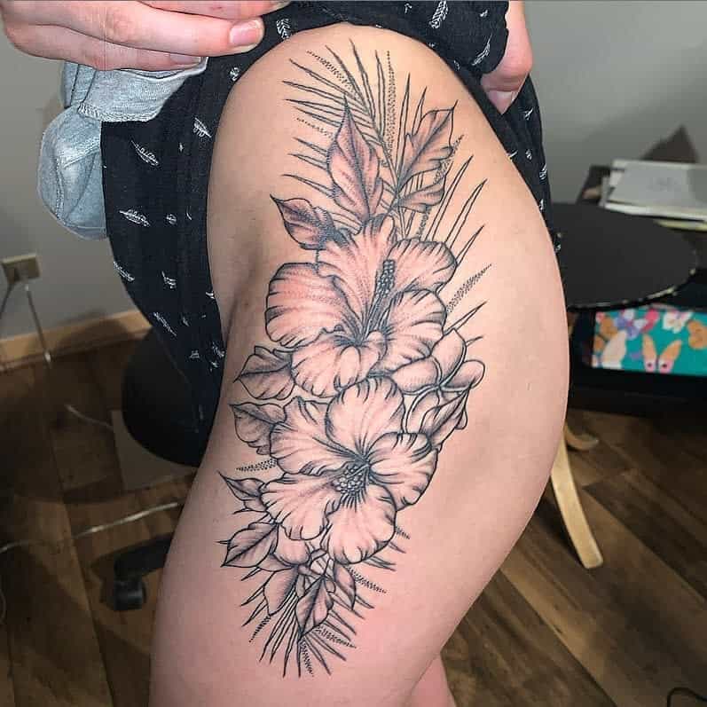 Thigh tattoo of hibiscus flowers and leaves in black ink