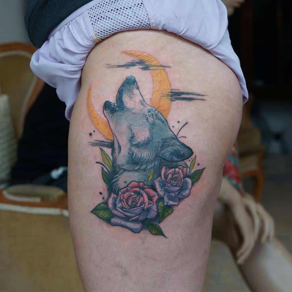 Tattoo of a wolf howling at an orange crescent moon with purple roses on a thigh