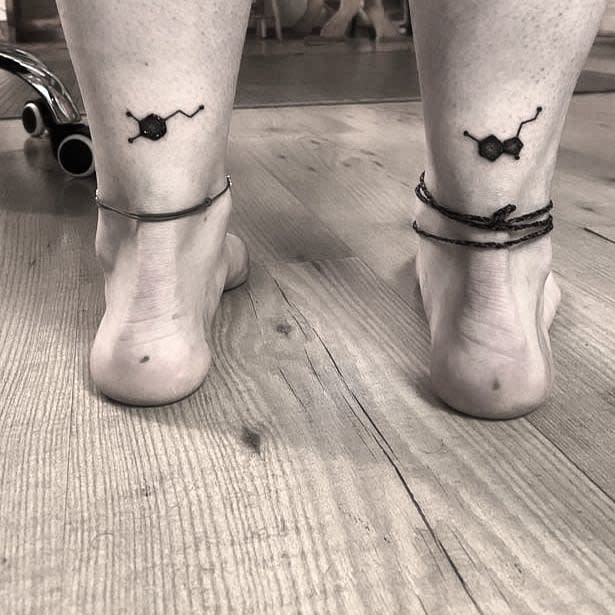 Minimalist serotonin molecule tattoos on the back of both ankles